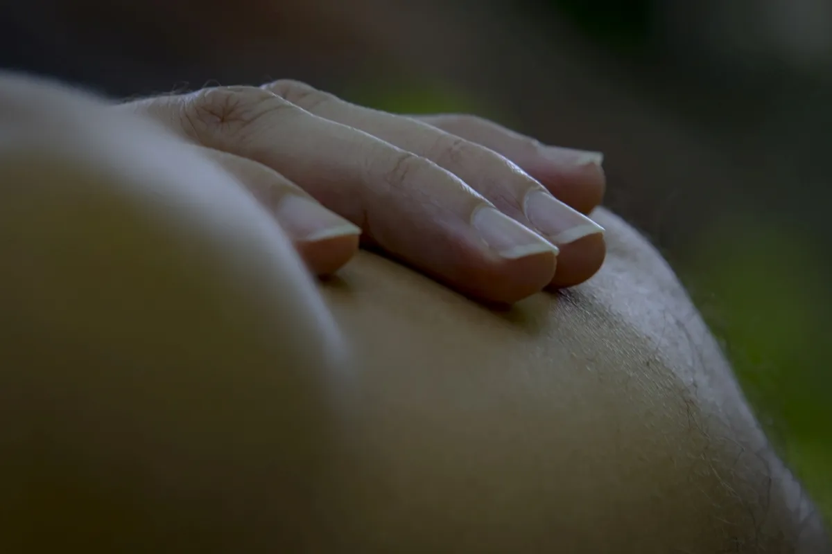 Close-up of a hand resting on bare skin